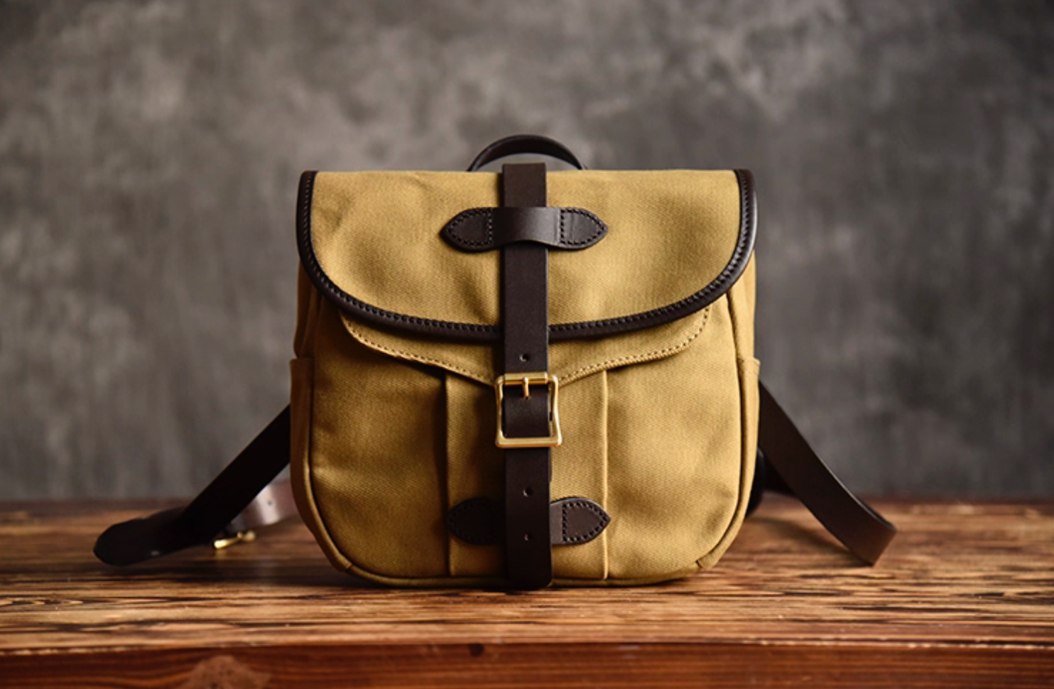 Front view of Nomad Field Tan waxed canvas satchel with leather strap and brass buckle.