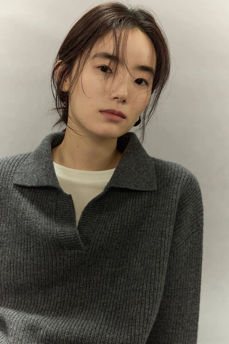 Close-up of ribbed polo collar and fine wool-cashmere texture in deep charcoal gray.