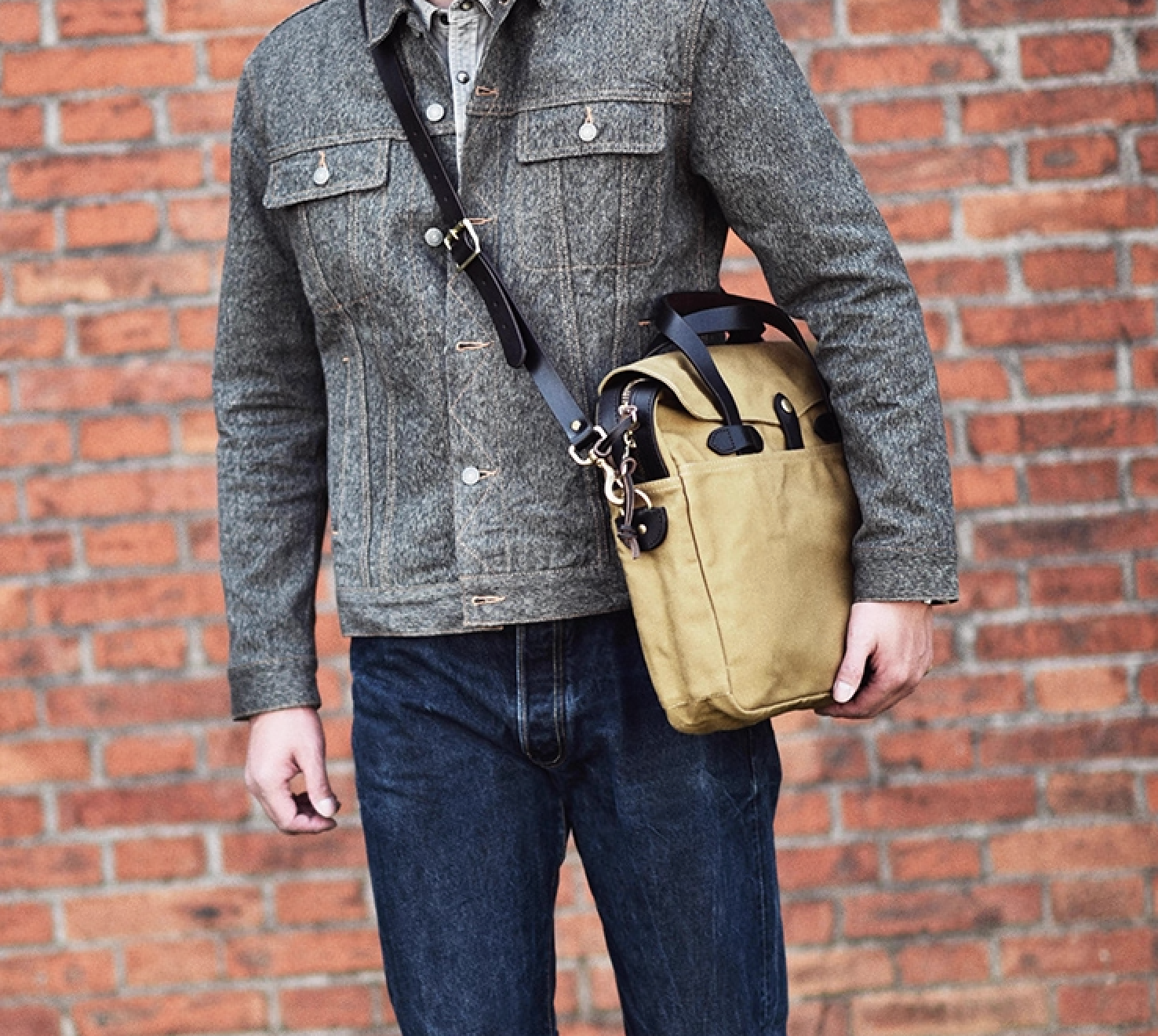 Man wearing khaki waxed canvas briefcase crossbody with leather strap
