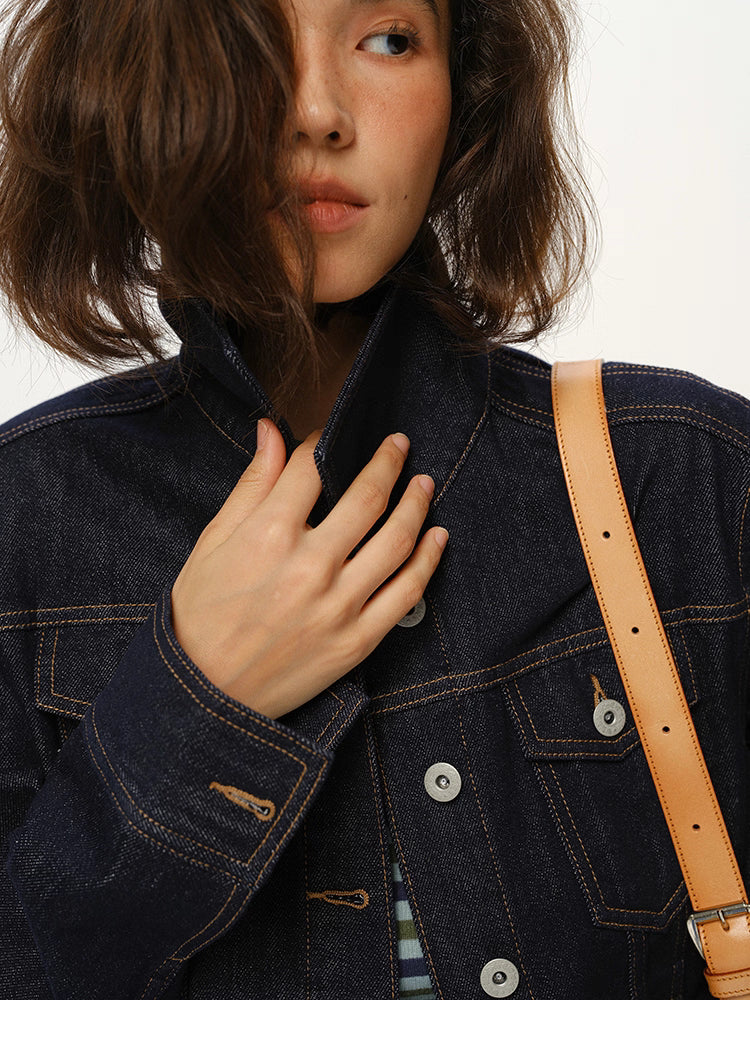 closeup of collar and stitching details on dark indigo denim jacket