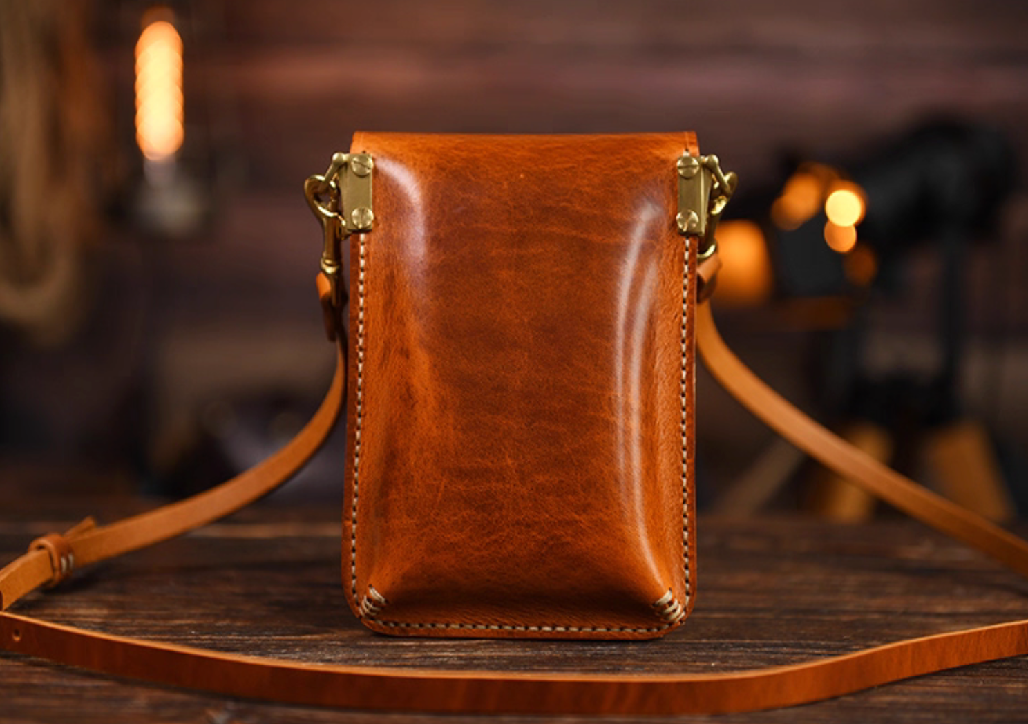 Back view of amber brown full-grain leather pouch with hand-stitching.