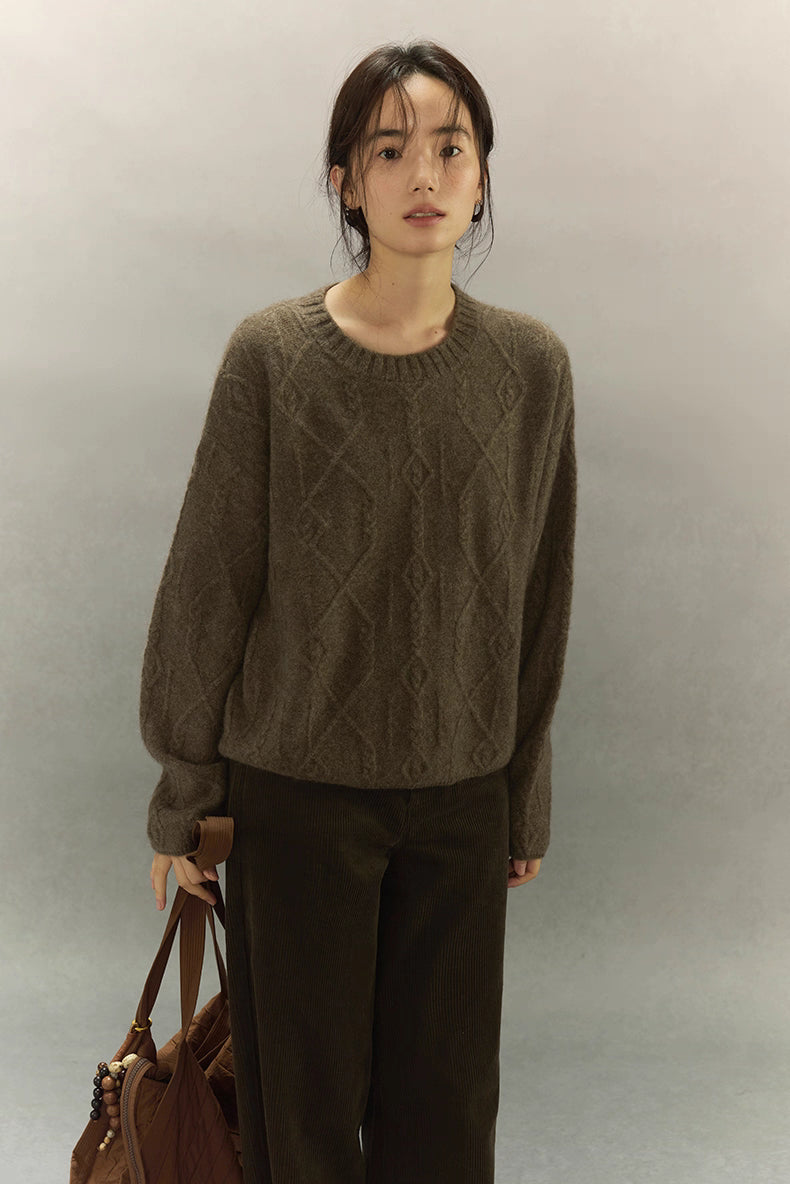 Model holding brown tote bag while wearing yak wool diamond knit sweater, full front pose