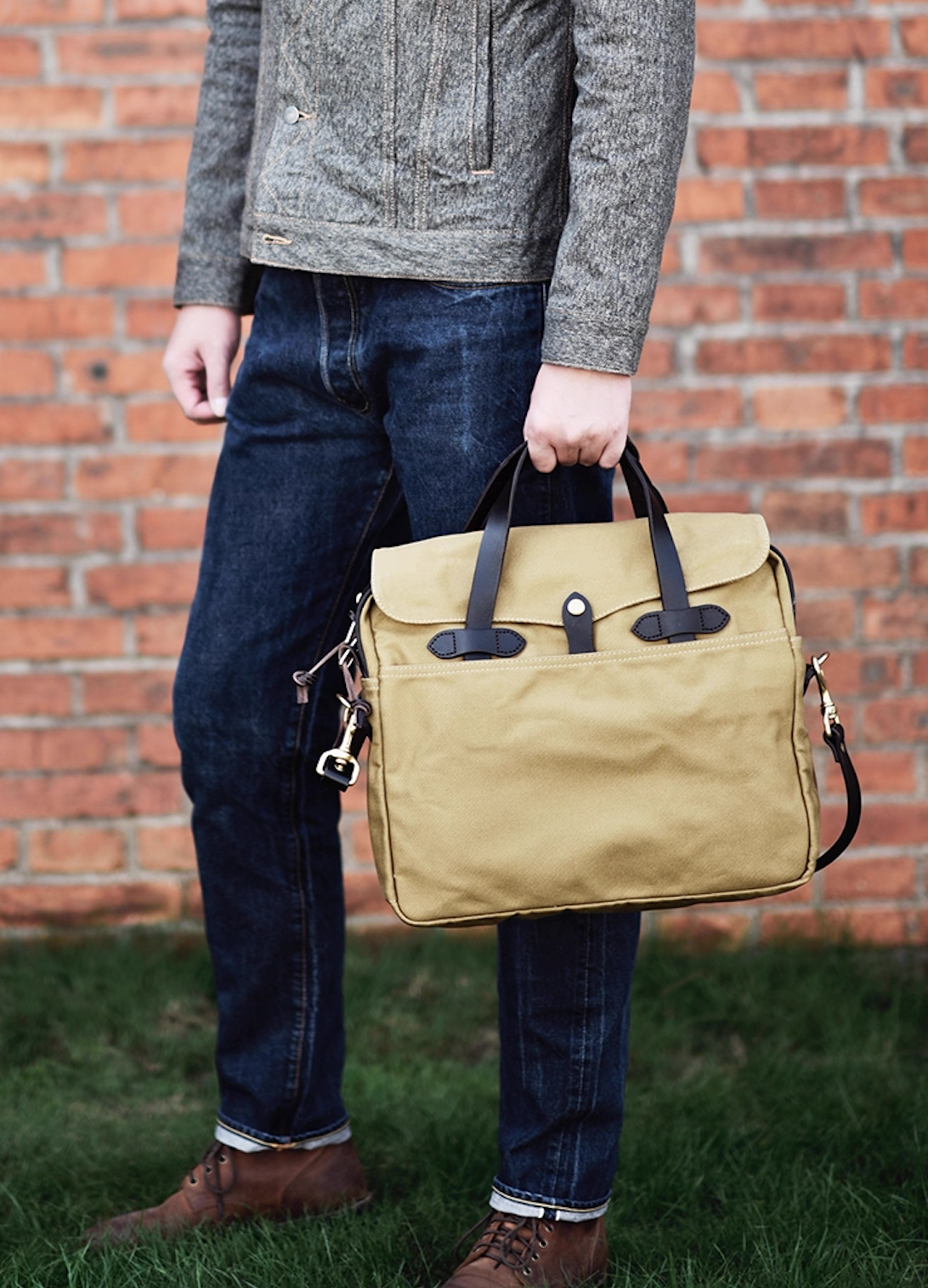 Man carrying khaki waxed canvas laptop briefcase by leather handles