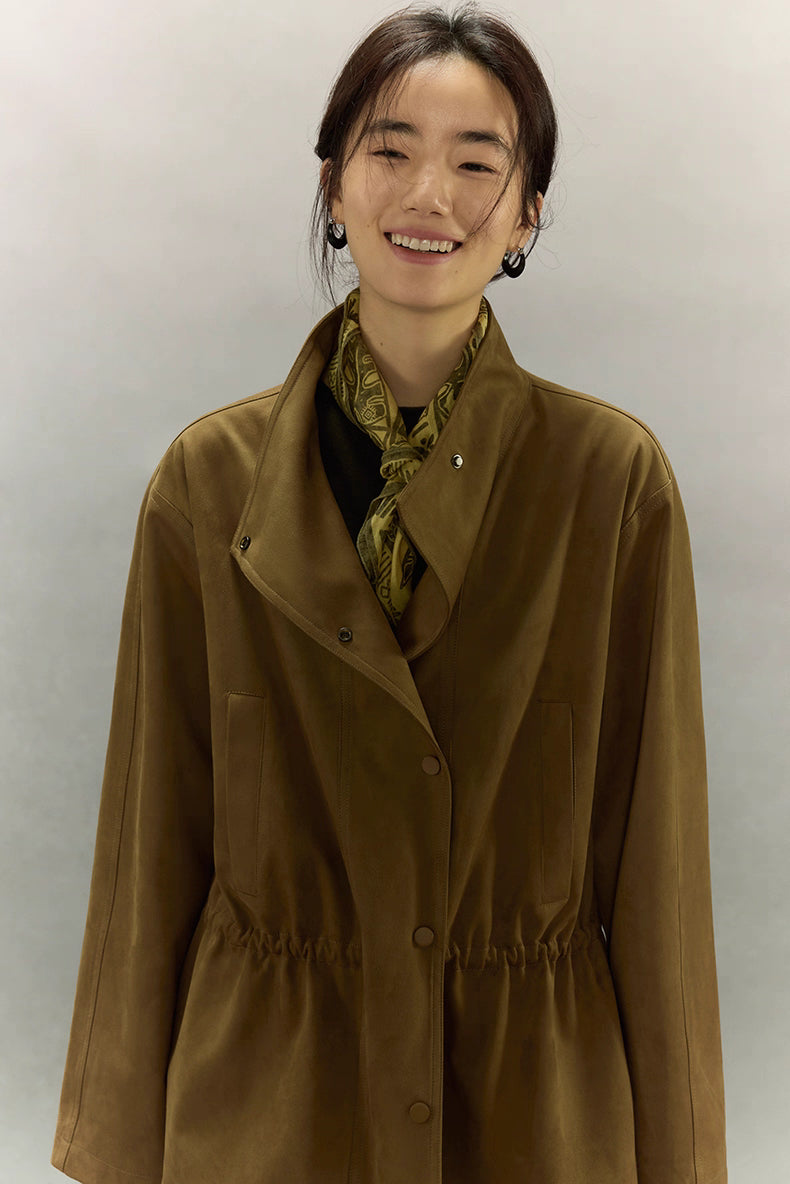 Model smiling while wearing caramel suede jacket with adjustable waist.