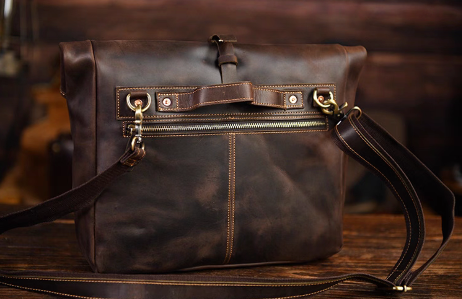 Back angle of messenger bag showing durable copper rivets and reinforced stitching