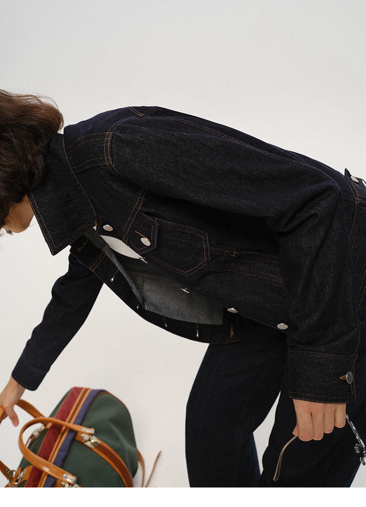 woman bending forward while wearing dark indigo cropped denim jacket