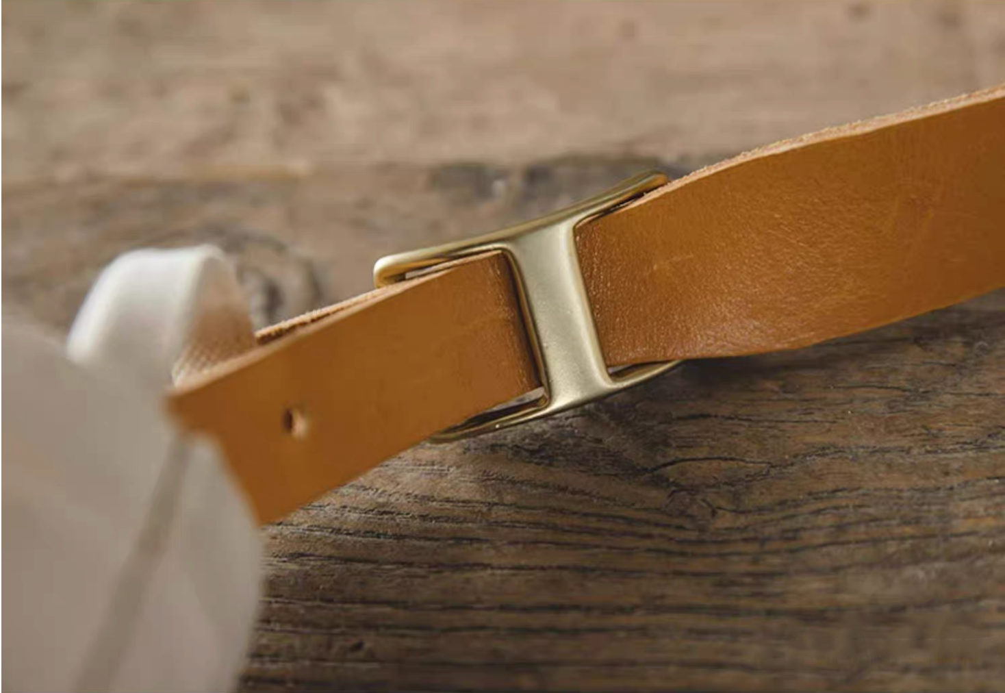 Close-up of tan leather strap and brass buckle craftsmanship