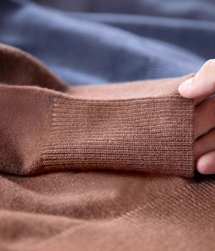 Detailed view of mocha brown sweater cuff showing dense ribbed knit