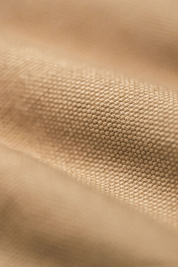 Detailed close-up of heavyweight khaki canvas fabric texture of Santafe jacket.