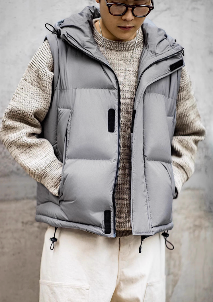 Model wearing grey hooded vest version of Versatile Parka with knit sweater