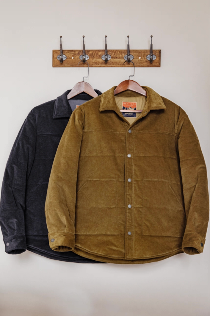 Earth yellow and navy blue corduroy padded jackets hanging on rack