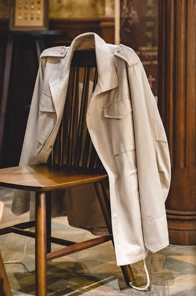 Sand Beige M65 Field Jacket draped on wooden chair showing soft cotton texture