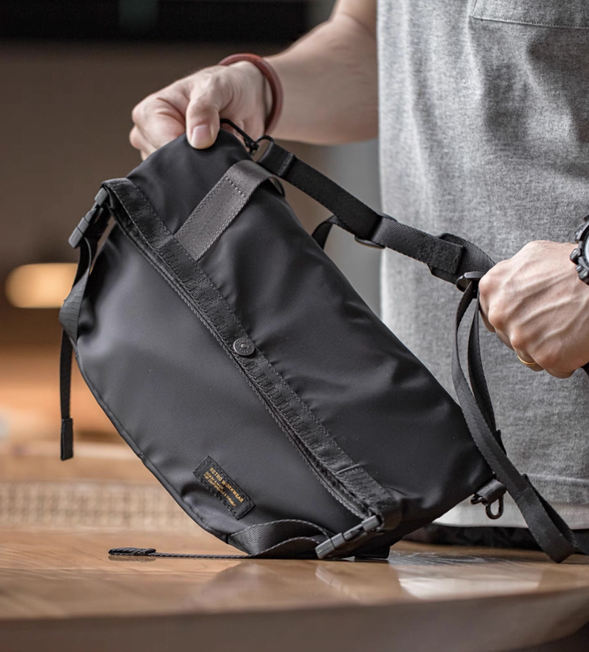 Close-up of man holding Yama Style black cycling bag with adjustable straps