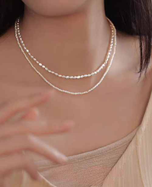 Model wearing classic pearl silver necklace layered double strand featuring fine freshwater pearls and delicate silver chain