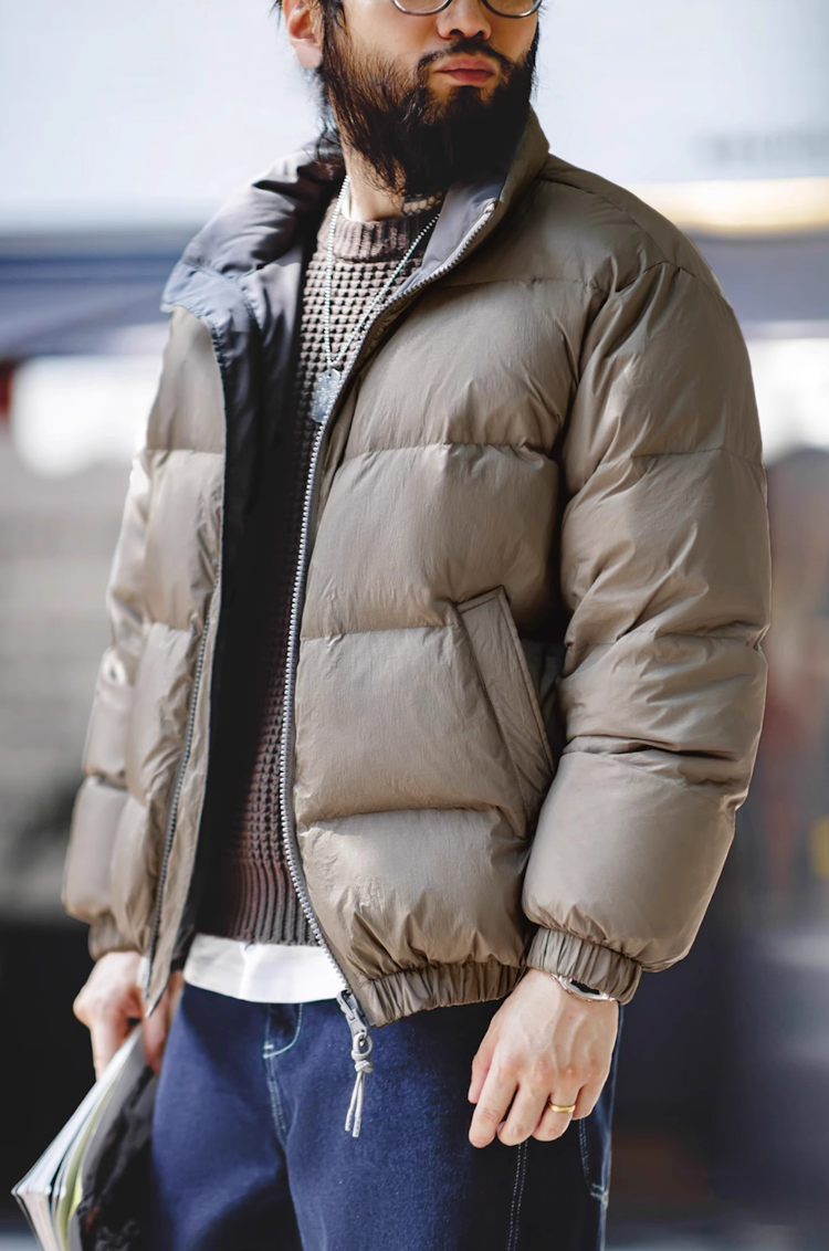 Side view of model in beige Reversible Down Jacket with layered winter outfit