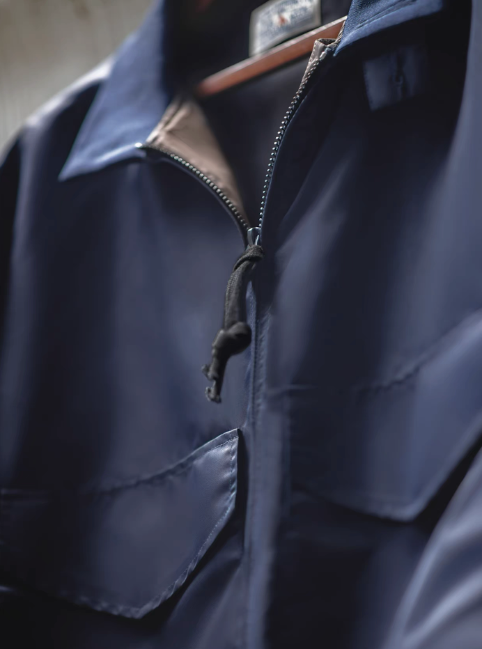 Close-up of zipper pull and nylon texture on G-8 Navy Flight Jacket, highlighting quality stitching.