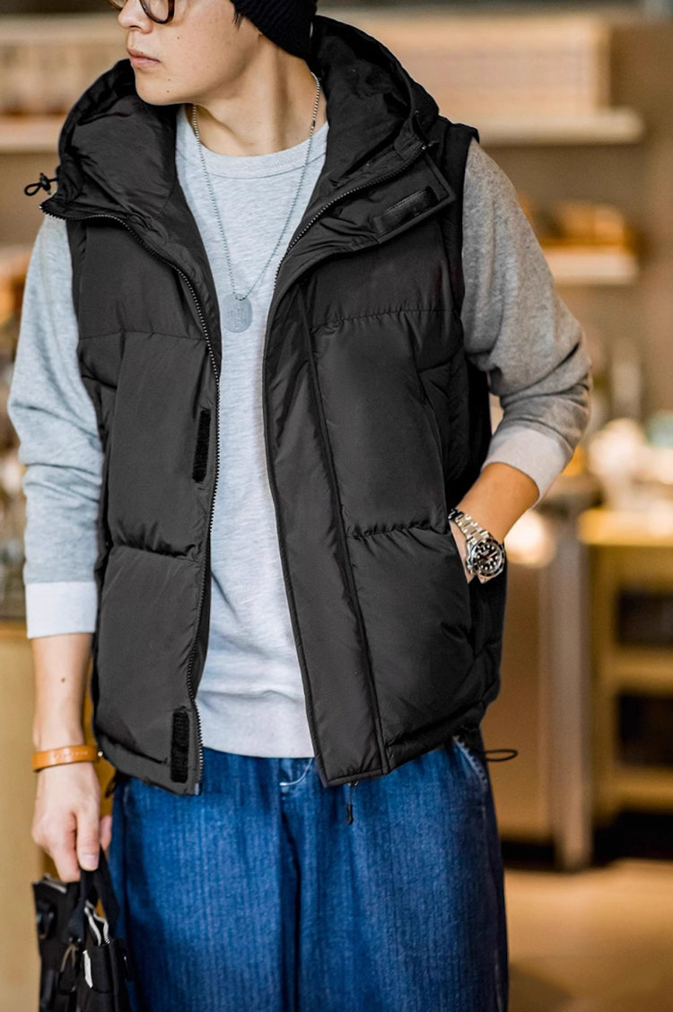 Model wearing black hooded vest version of Versatile Parka with gray sweatshirt