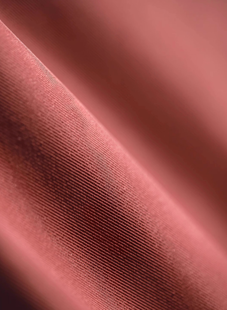 Close-up of durable cavalry twill texture in brick red color