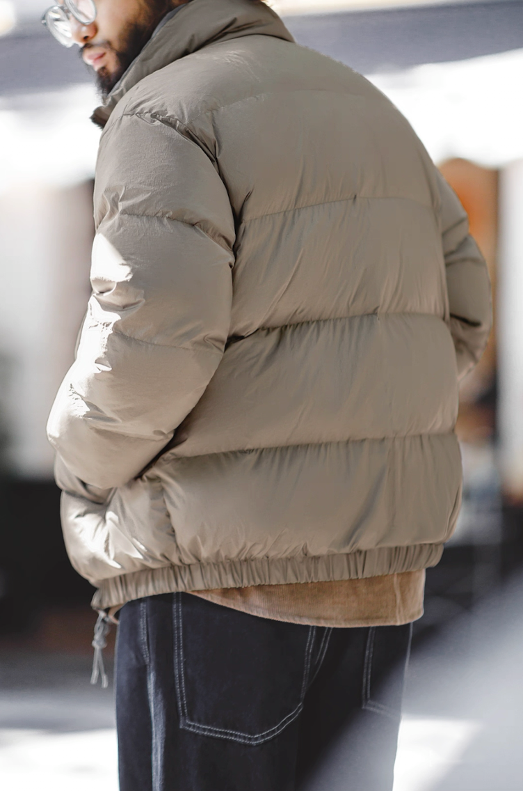 Back view of beige Reversible Down Jacket showing quilted texture and shape
