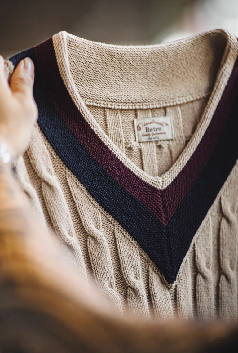 Close-up of V-neck trim showing navy and burgundy stripes and soft knit texture