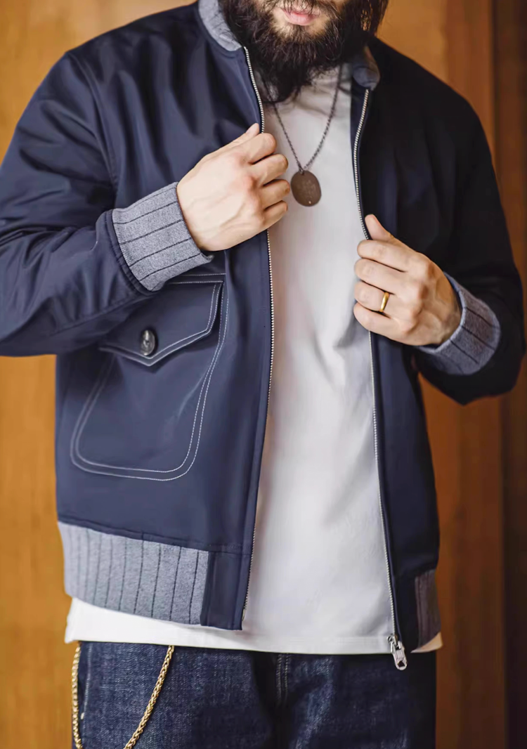 Man zipping up navy A1 flight jacket in casual indoor setting
