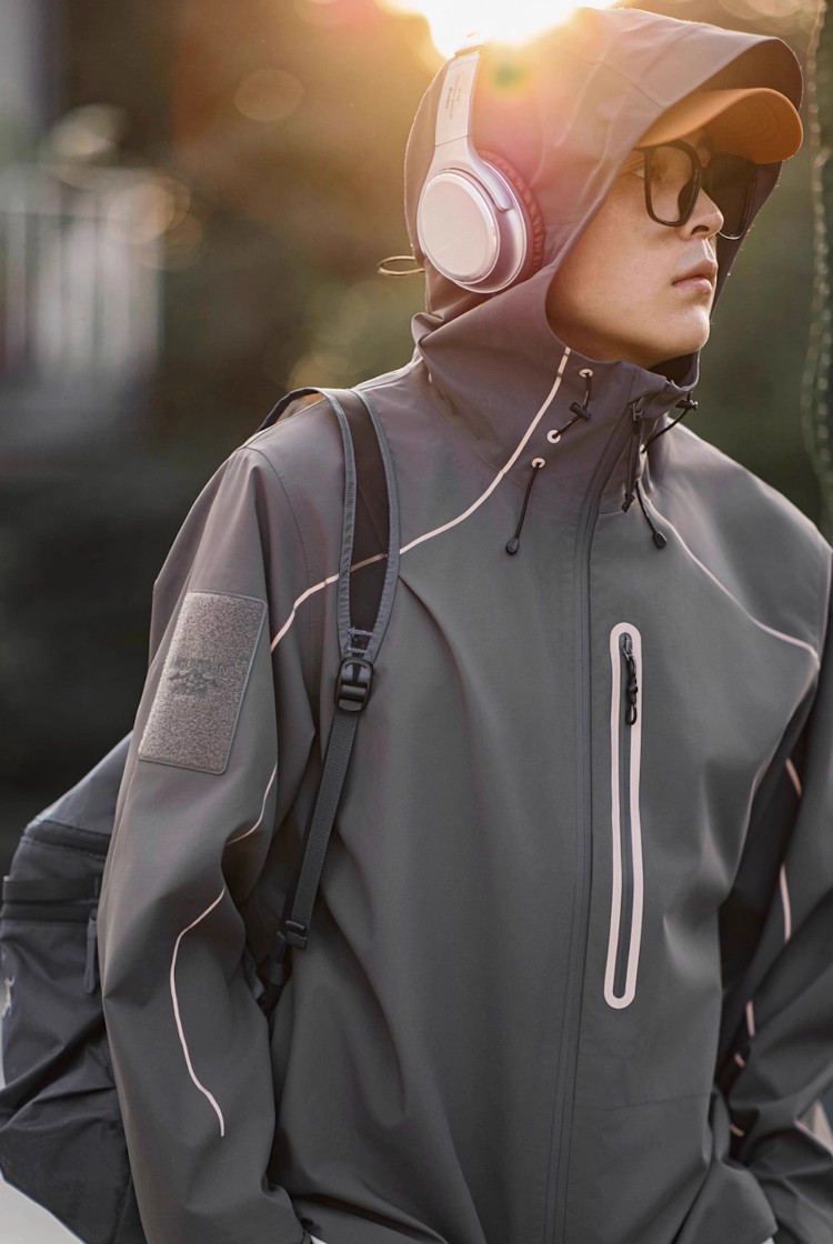 Model wearing grey LIGHTSABER waterproof jacket in natural outdoor light