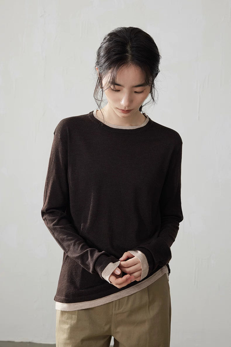 Model looking down wearing dark brown knit top with beige contrast trim and khaki pants