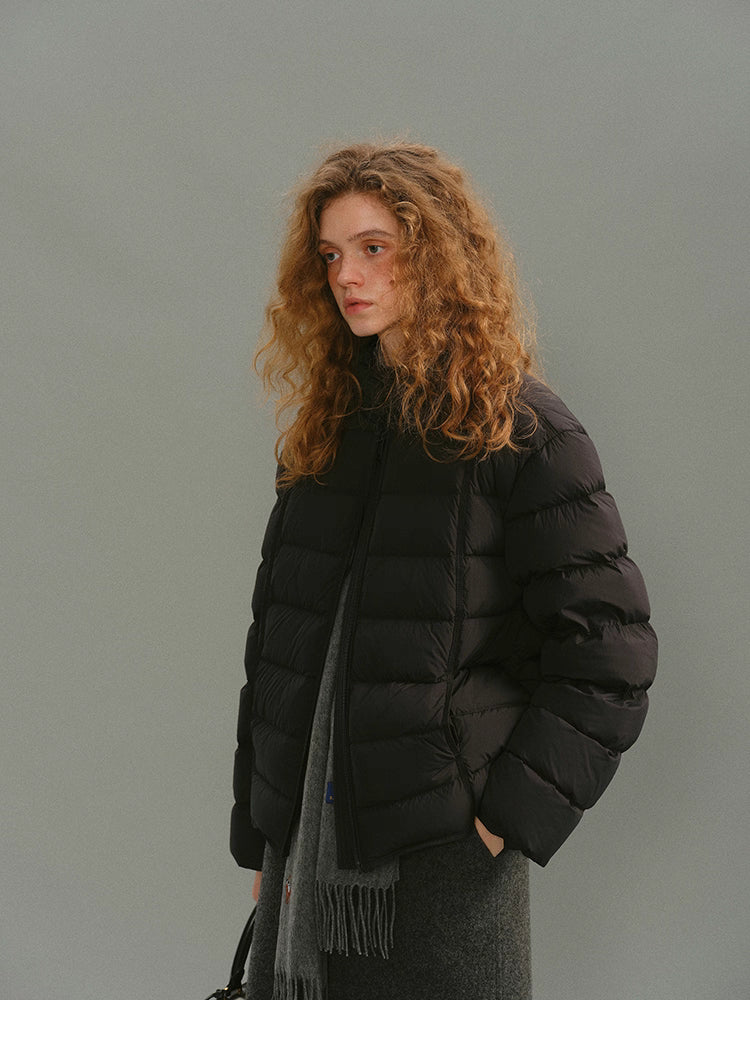 Model wearing a black matte AirSoft down puffer with a grey scarf.