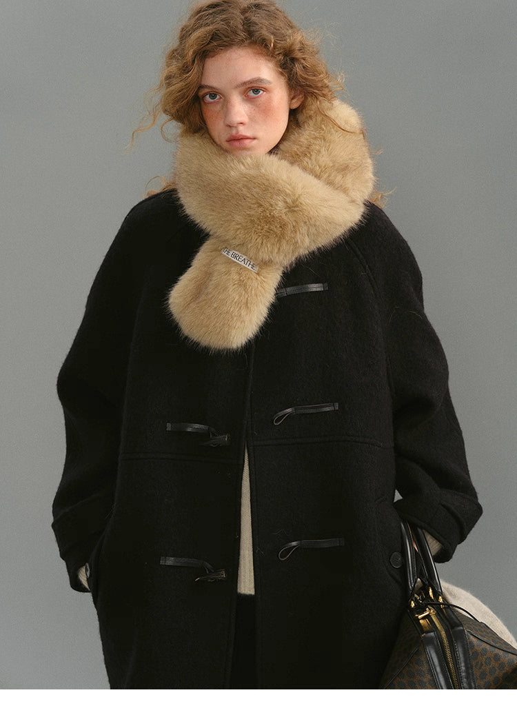 Black toggle coat styled with a beige fur scarf on the model.