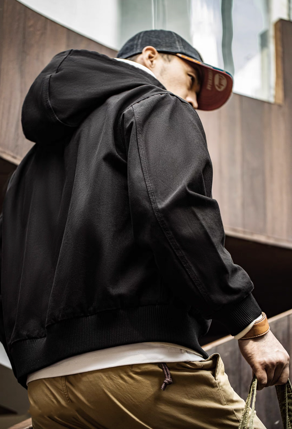 Back view of Black Adventure Ready Hooded Jacket worn by model showing hood structure, relaxed fit and ribbed hem finish