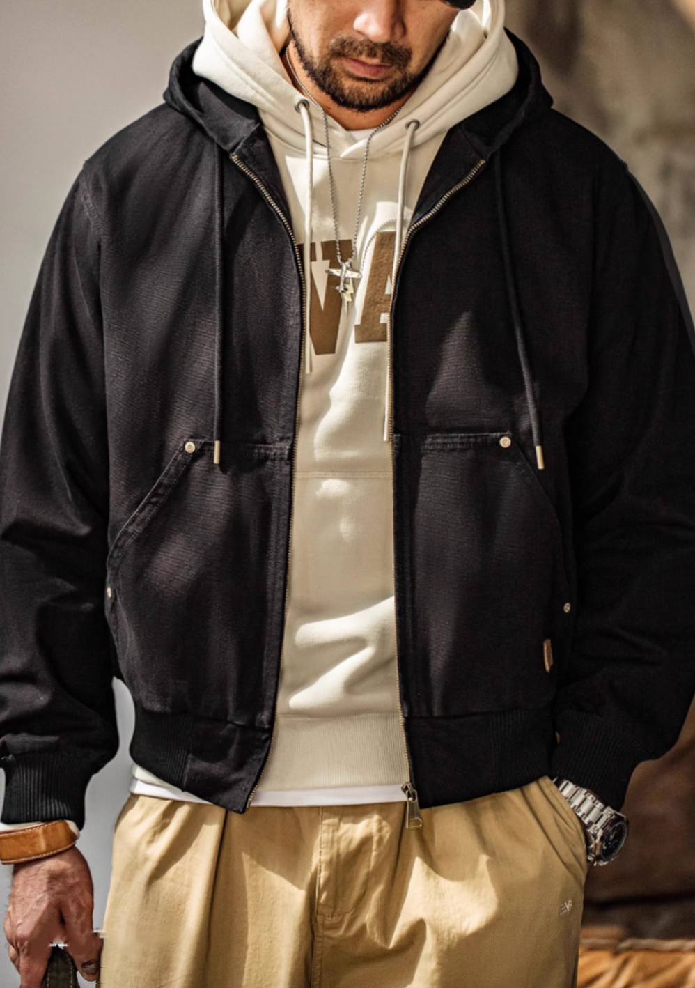Man wearing Black Adventure Ready Hooded Jacket layered over hoodie showing front zip design and casual styling