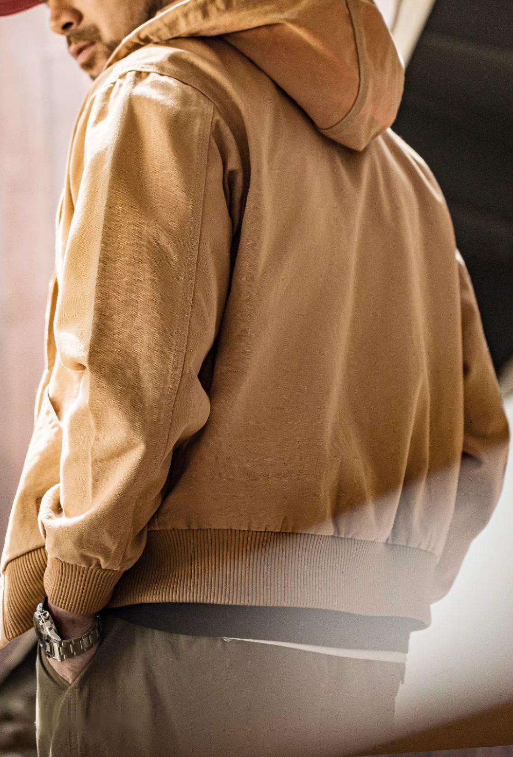 Back view of Khaki Adventure Ready Hooded Jacket worn by model highlighting hood shape, smooth fabric and ribbed waistband