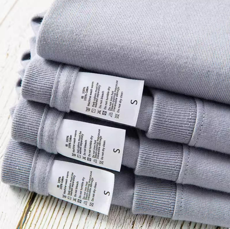 All-Day Comfort Tee Purple Gray cotton fabric care label detail stacked T-shirts close-up