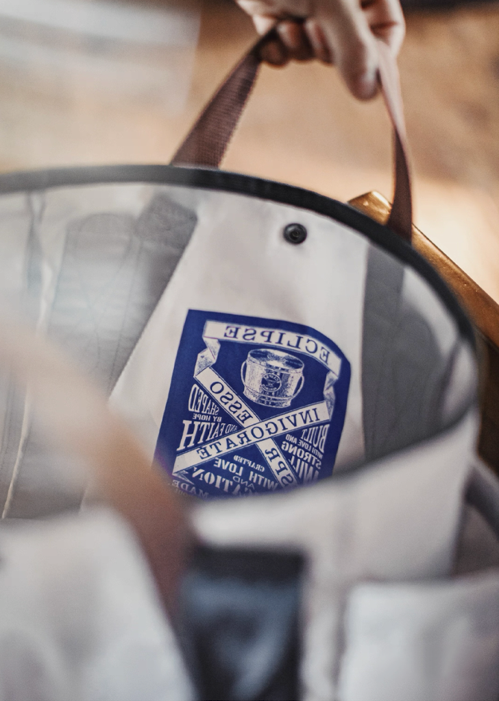 Close-up of reflective “Every Effort Made” vintage print inside tote bag