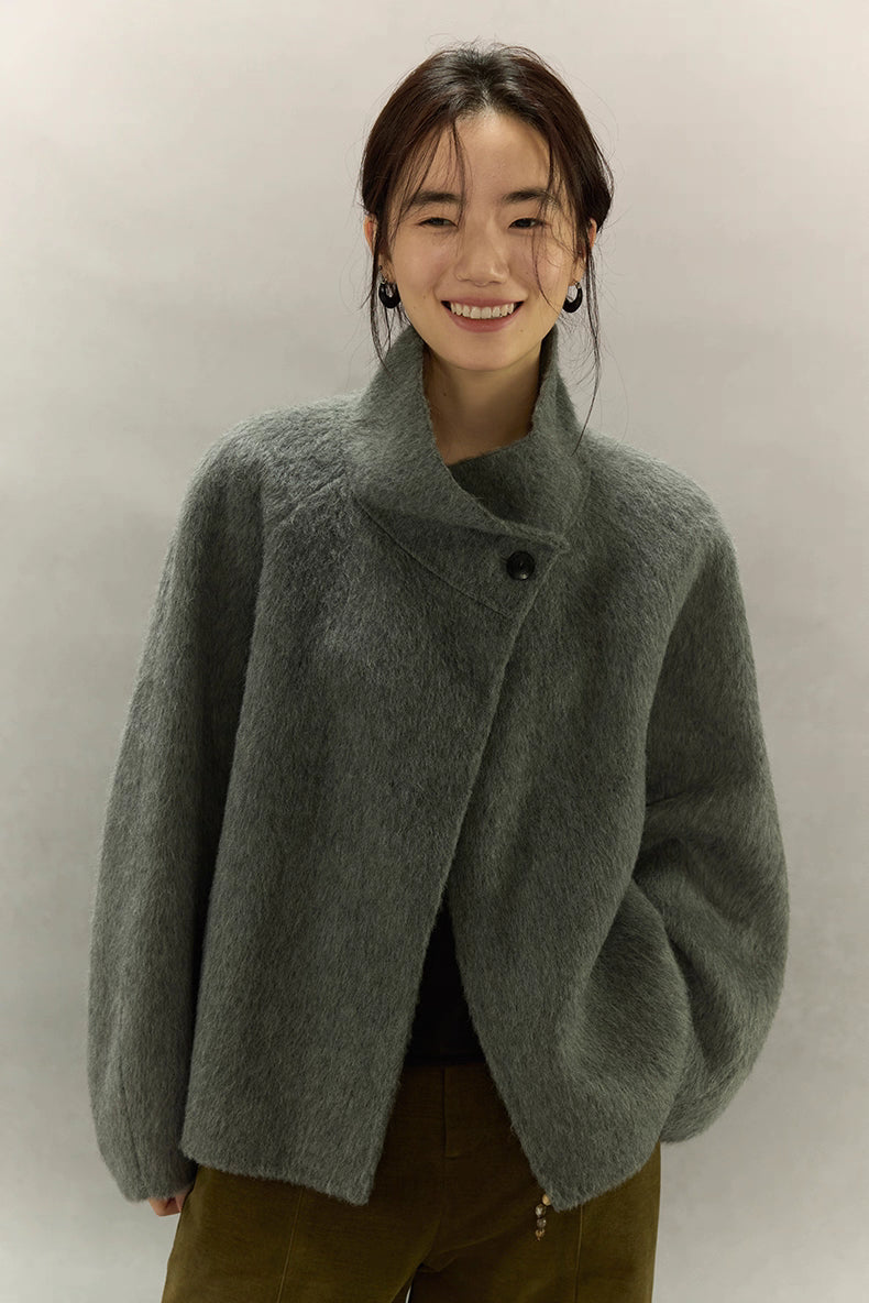 Model smiling in sage gray natural alpaca sculpted-collar jacket, front view