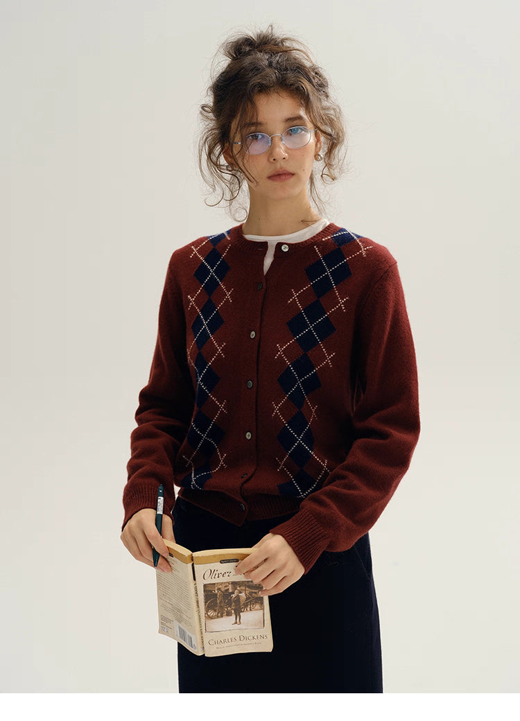 model standing wearing wine red argyle wool cardigan holding book