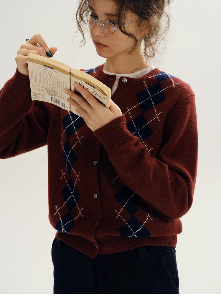 model reading book wearing wine red argyle cardigan front view