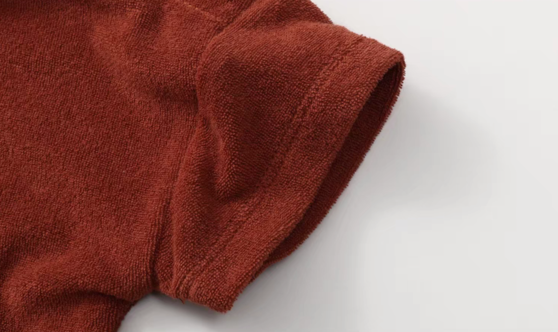 Close-up of rust red terry cotton sleeve showing soft textured fabric detail