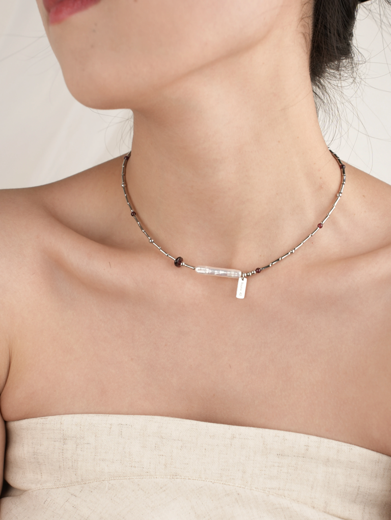 Close-up of model wearing Baroque Elegance Layered Necklace in garnet with baroque pearl and silver chain