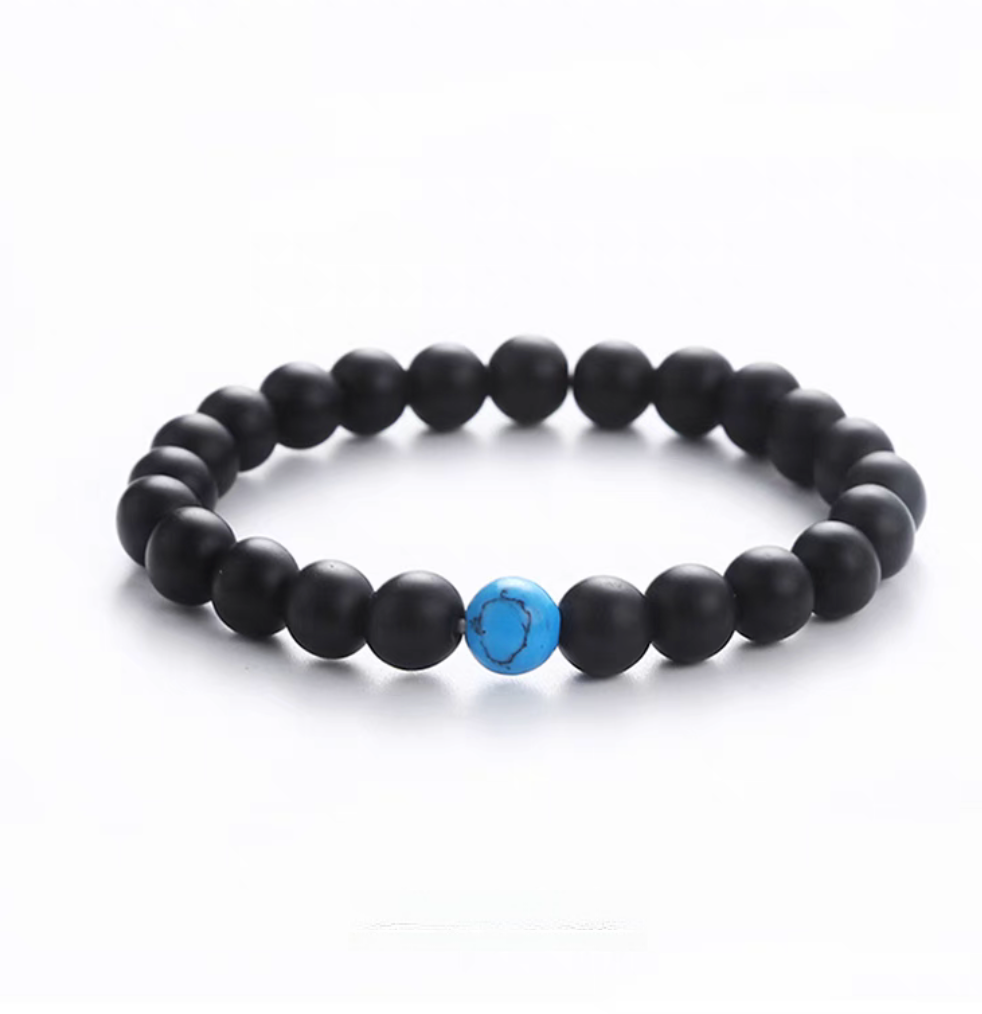 Matte black stone minimal bead bracelet with a single blue turquoise accent bead for contrast