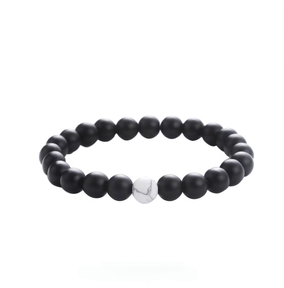 Matte black stone minimal bead bracelet featuring a single white turquoise accent bead