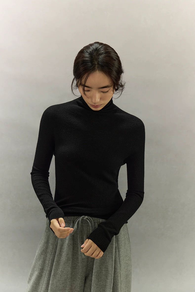 Detailed front view of Black turtleneck showing bark-texture and slim fit.