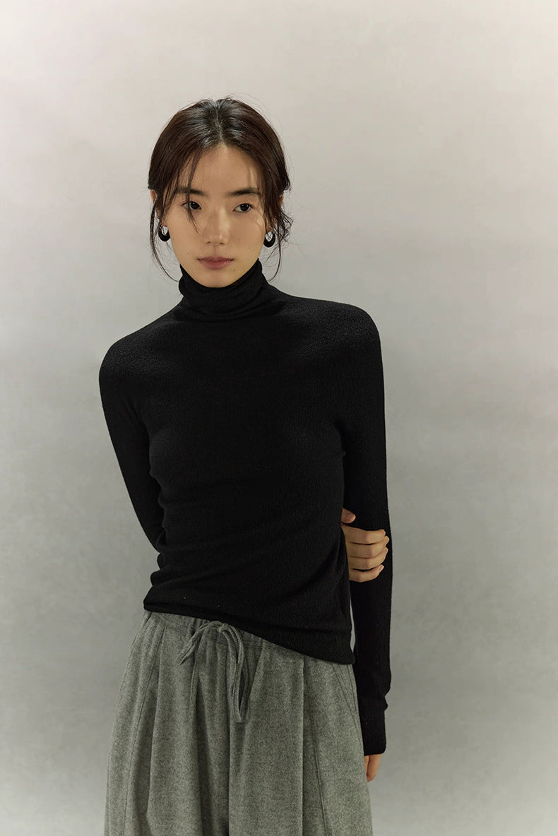 Model wearing Black turtleneck in relaxed standing pose, full front view.