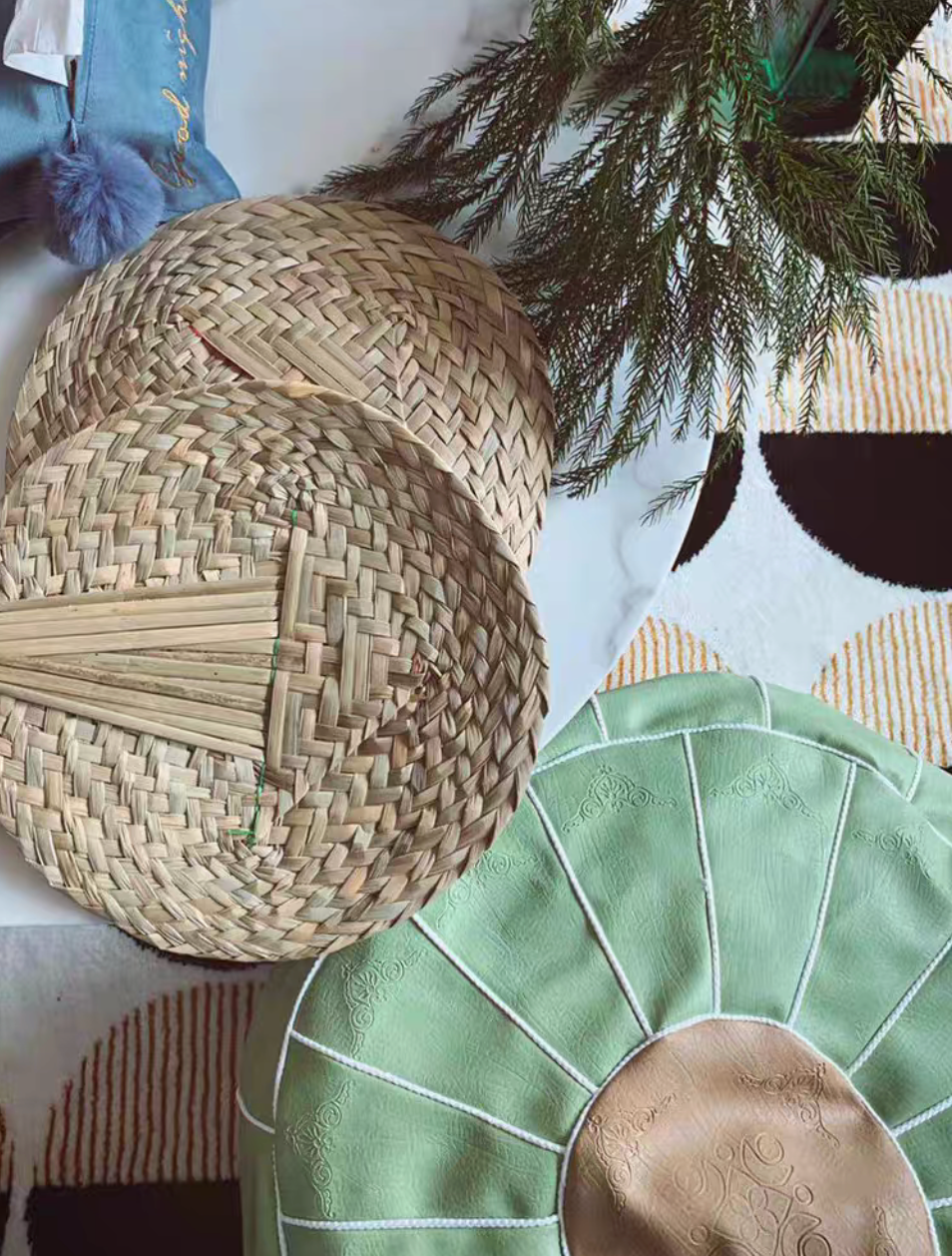 Light green faux leather pouf styled with woven basket and textiles in boho decor setting