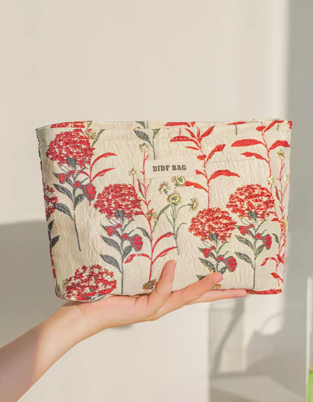 Botanical Embroidered Zip Makeup Pouch in red floral embroidery held in hand showing size and structure