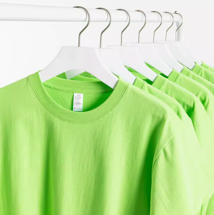 Multiple green cotton T-shirts hanging on rack showing consistent color and fit