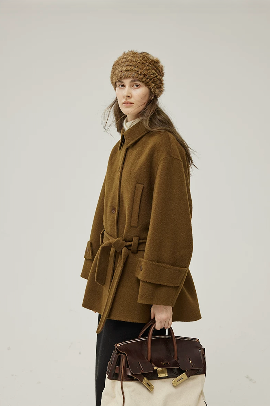 Side view of a Brown belted wool coat showing the welt pocket, wide cuff, and boxy cut