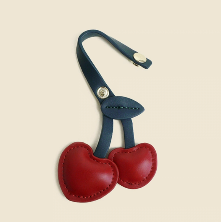 Red cherry heart keychain with open snap strap showing attachment loop and leaf detail