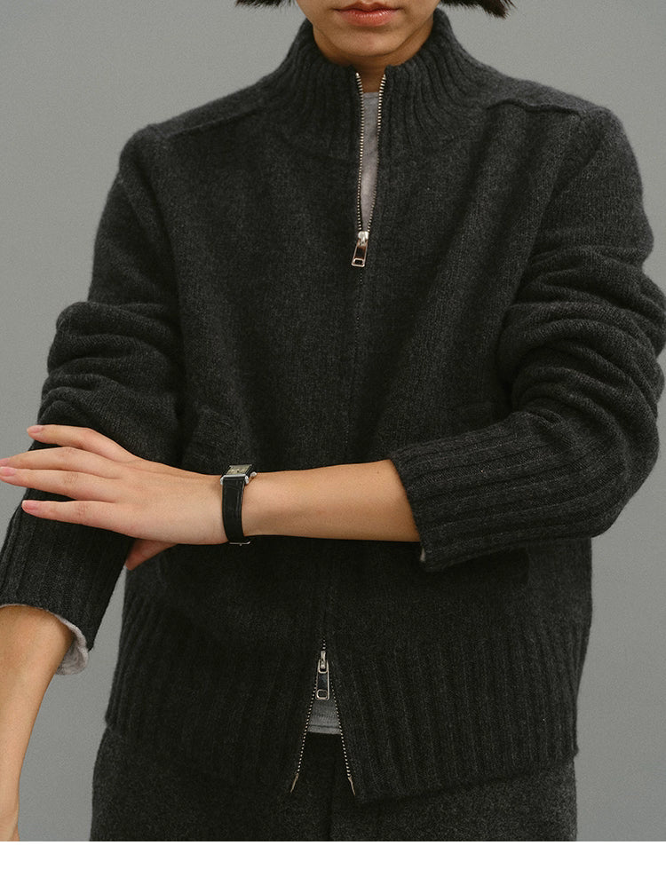 Close-up detail of charcoal wool zip-up cardigan showing ribbed collar and zipper
