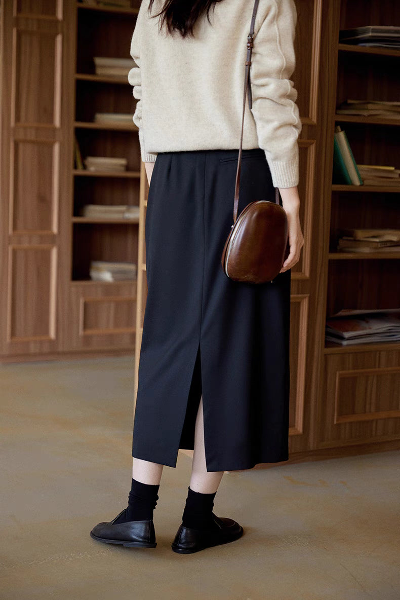 Back view of The Classic Sculpted Midi Skirt in black featuring subtle back slit for movement and tailored fit design